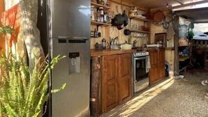 Eine rustikale Küche mit Holzschränken, einem Edelstahlkühlschrank und einem Herd.