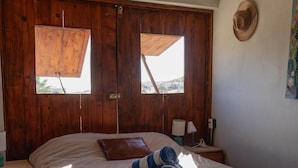 Ein Schlafzimmer mit einem großen Bett, einem Holzschrank und einem Koffer auf dem Boden.