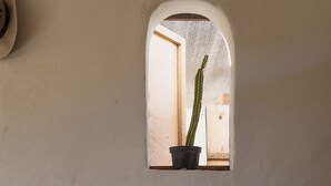 Ein Stuhl und ein Tisch in einem Raum mit einem kleinen Fenster.