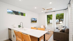 Une cuisine moderne avec un coin repas, un canapé et une vue sur l’extérieur.