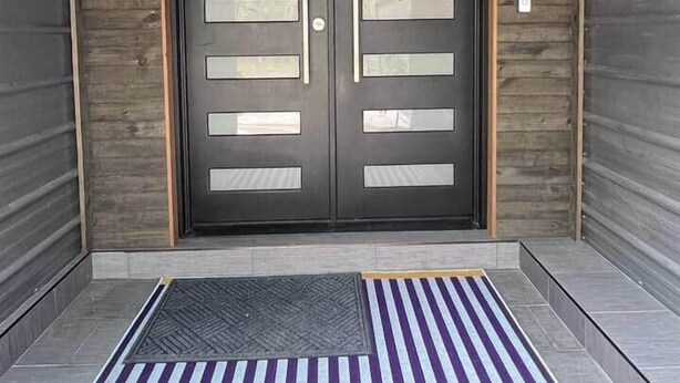 A lobby entrance with a double door, a neon sign above, and a striped mat at the entrance. - Purple Rain/Pop Culture 2bd 2bth Luxury Pool Hot Tub (Lutz)