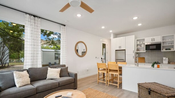 A modern living room with a sofa, coffee table, and dining area. - Waltz On In | 1BR King | Pool + River | Pets Welcome (New Braunfels)