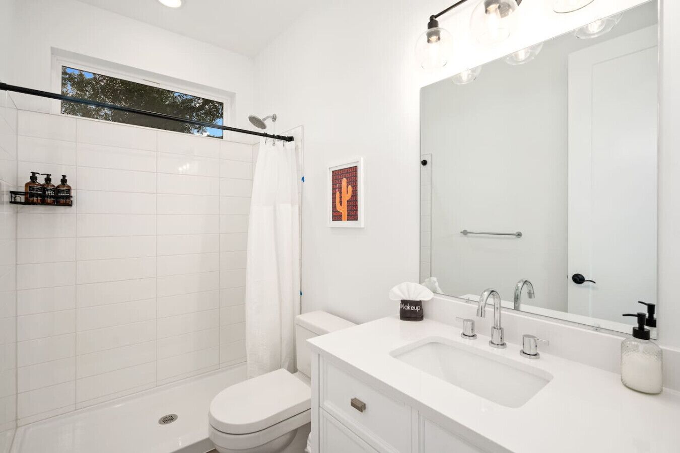 Un bagno moderno con doccia, WC, lavandino e uno specchio grande.