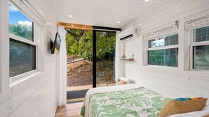 Een slaapkamer met een bed, een raam en uitzicht op de omgeving.