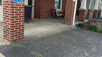 Een gebouw met een bakstenen gevel, een overdekte veranda en een toegang voor mensen met een handicap.
