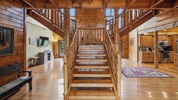 A wooden staircase with a railing, leading to a second floor.