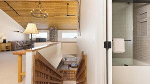 A modern interior with a wooden staircase, a stone accent wall, and a glass shower area. - *New to Market* 5 Bedroom Big Sky Resort Condo (Big Sky)
