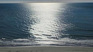 Ein Strand mit blauem Himmel und ruhiger See.
