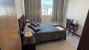 A hotel room with a bed, a nightstand, a desk, and a chair. - Your best spot in Ipanema, just steps from the sea and the lagoon. (Rio de Janeiro)