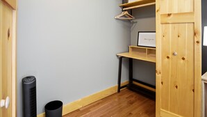 A room with a wooden cabinet, a black trash bin, and a framed picture on a shelf. - Newly Refreshed : Knotty Pine Cabin + Hot Tub (Logan)