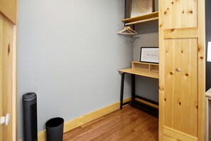 A room with a wooden cabinet, a black trash bin, and a framed picture on a shelf. - Newly Refreshed : Knotty Pine Cabin + Hot Tub (Logan)