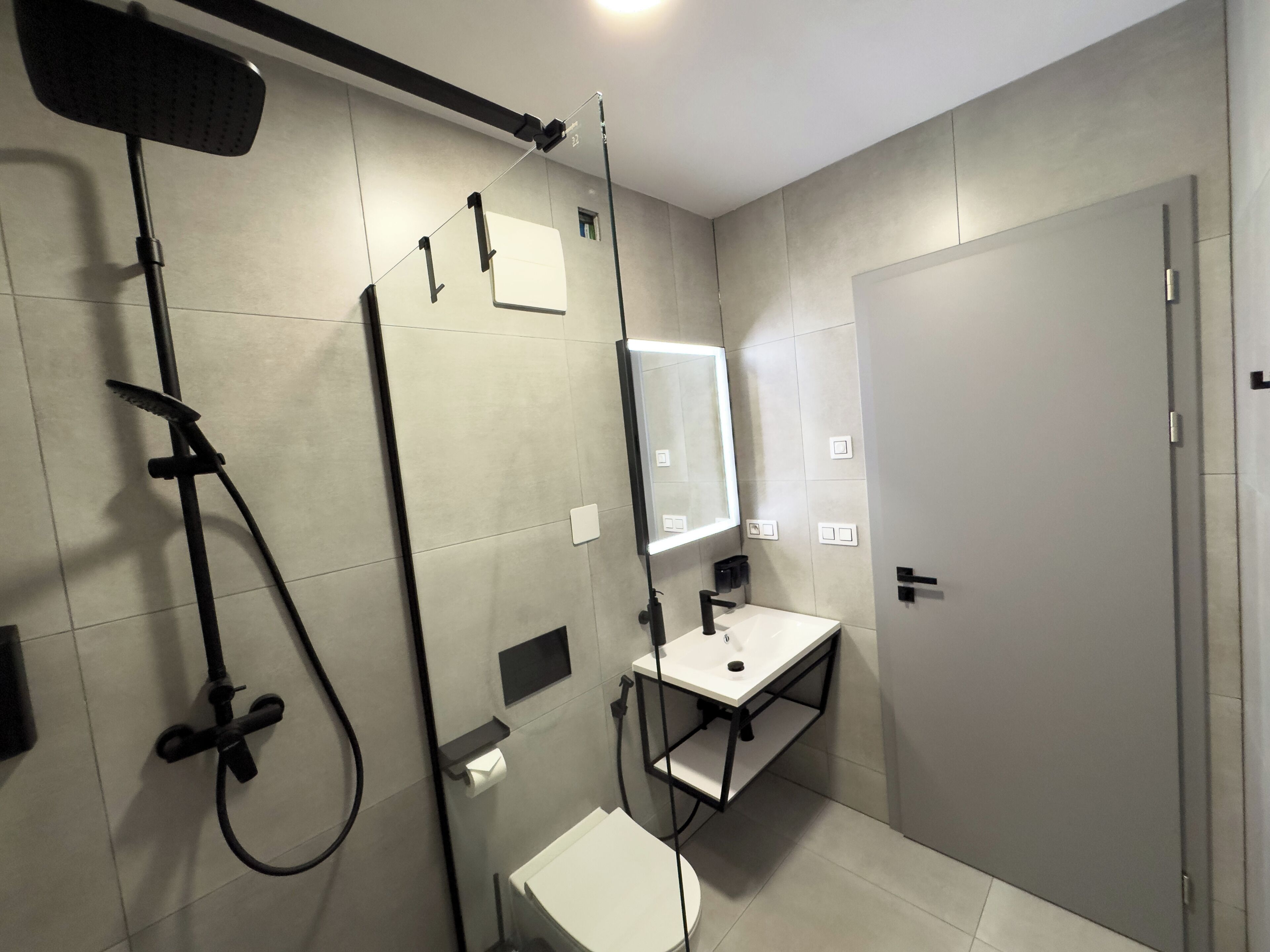 Un baño moderno con ducha, inodoro y lavabo.