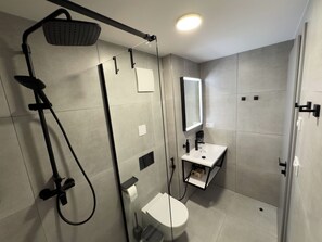 Ein modernes Badezimmer mit Dusche, Toilette und Waschbecken.