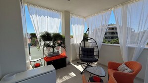 A balcony with a hanging chair, two armchairs, a small table, and a potted plant. - Saxony, close to the Center and the Sea Cozy new apartment (Fano)