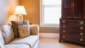 A room with a sofa, a lamp, and a wooden cabinet.