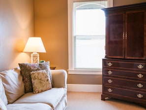 A room with a sofa, a lamp, and a wooden cabinet.