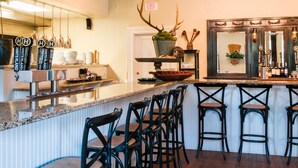A bar area with a counter, stools, and a decorative antler.