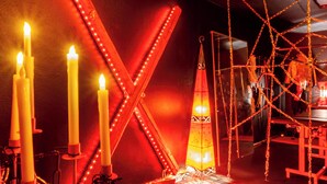 A room with a large X-shaped light fixture, multiple candles, and a hanging light. - Hourly hotel BlackKingdom (Freiburg im Breisgau)
