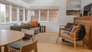 A modern living room with a sofa, chairs, a table, and a TV. - The Chance - Immerse yourself in the oceanic ambience of South Beach. (Port Fairy)