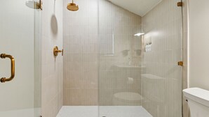 Ein modernes Badezimmer mit Duschkabine, Toilette und Waschbecken.
