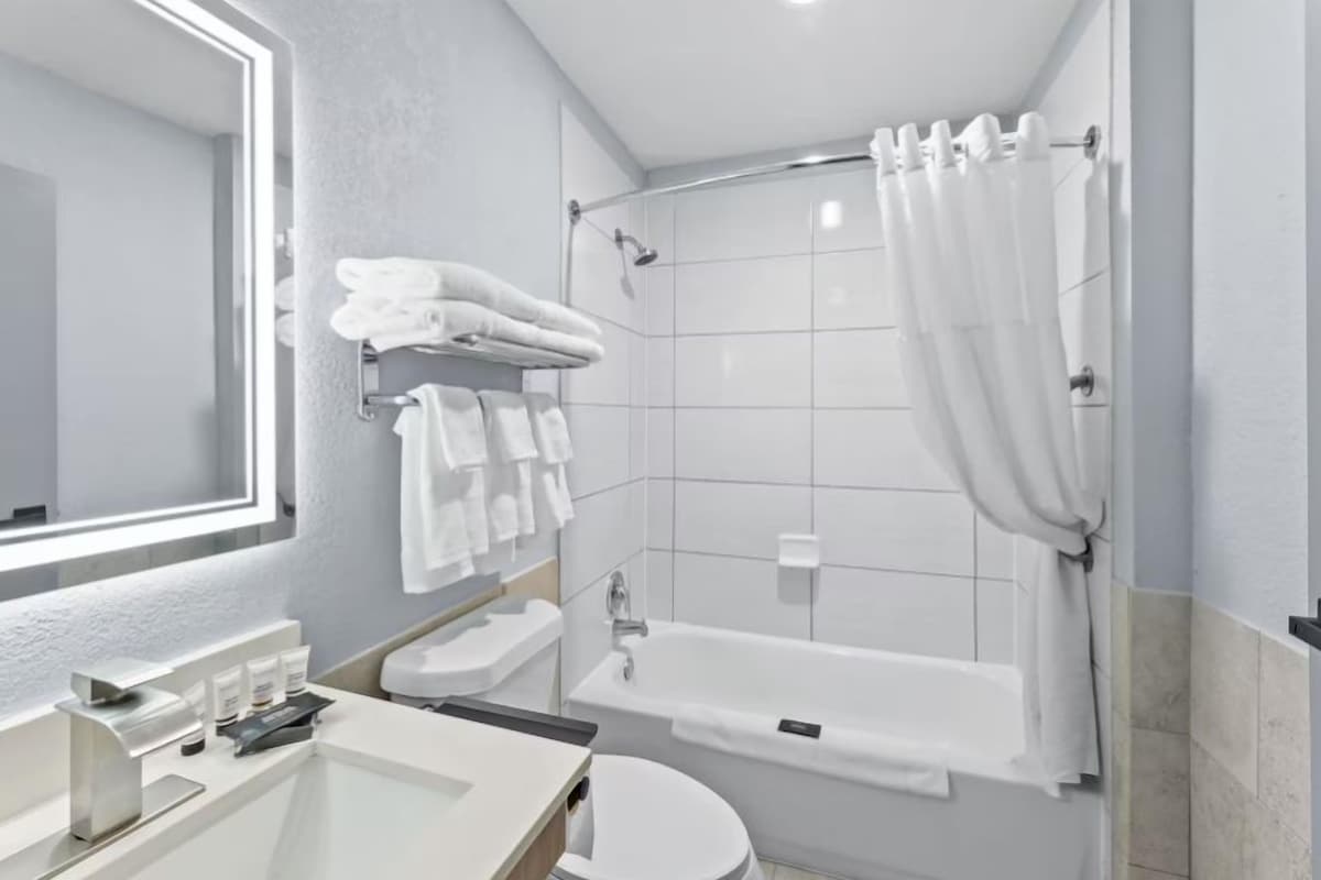 A modern bathroom with a bathtub, toilet, and sink.