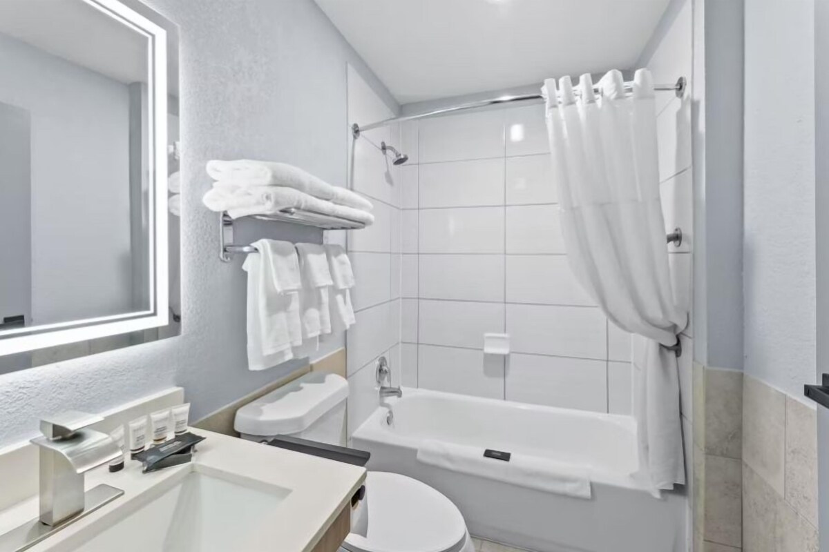 A modern bathroom with a bathtub, toilet, and sink.