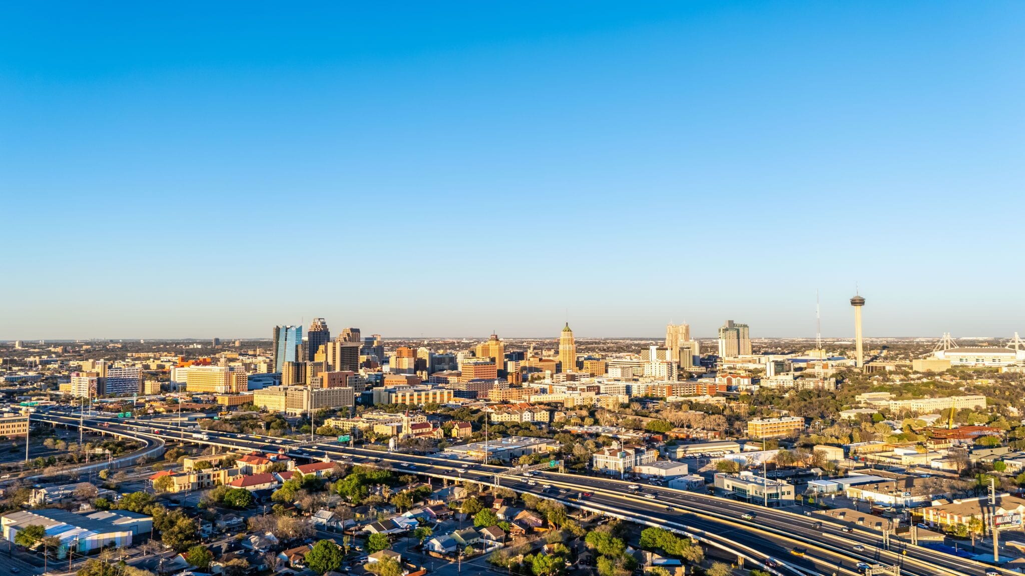 A cityscape with a mix of modern and historic buildings, a prominent tower, and a network of highways.