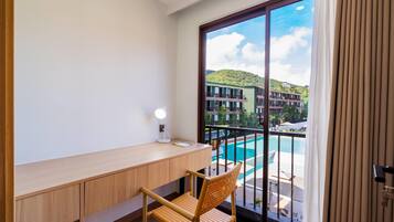 A balcony with a view of a swimming pool and buildings.