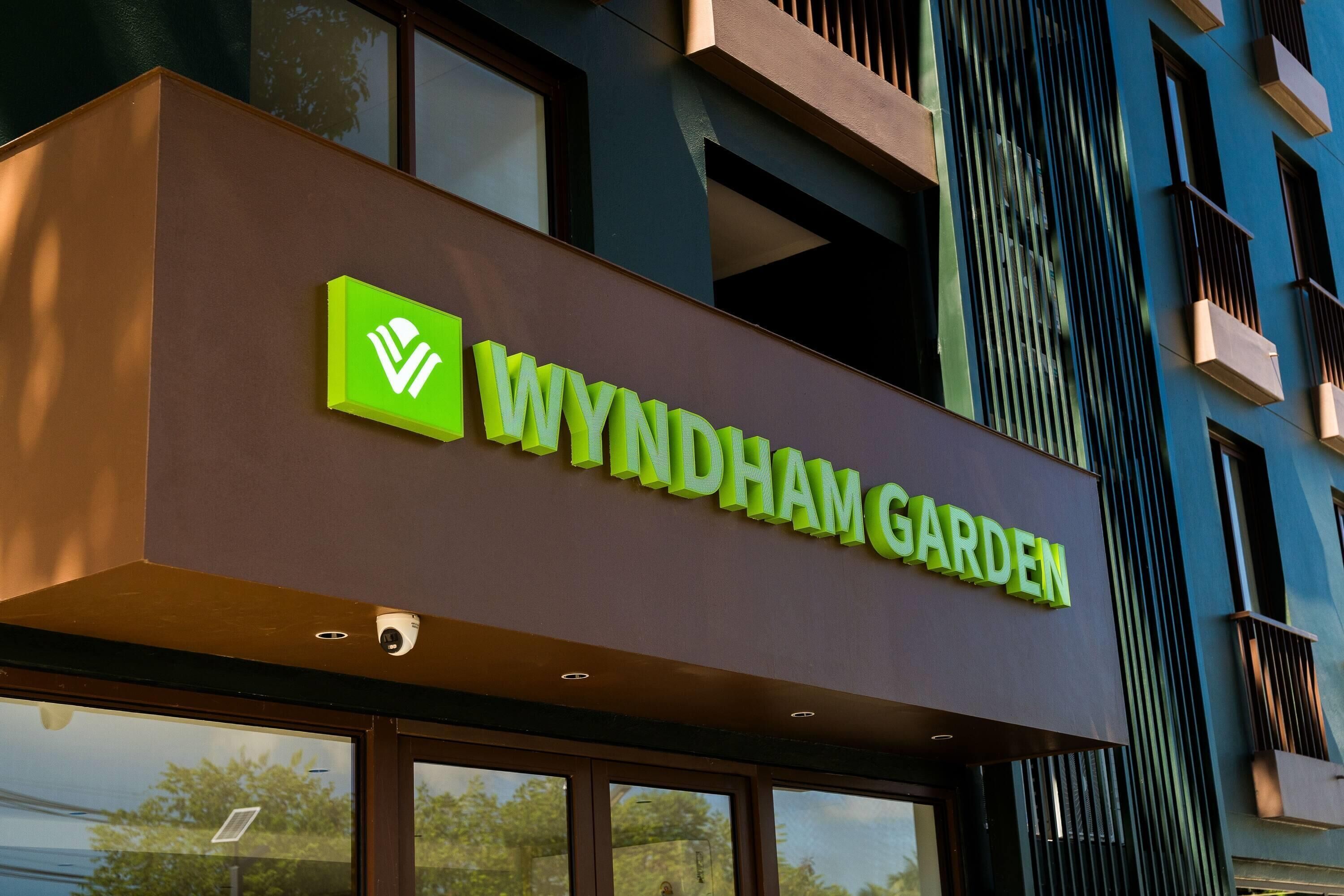 A sign for Wyndham Garden hotel with a green logo and the name in white letters.