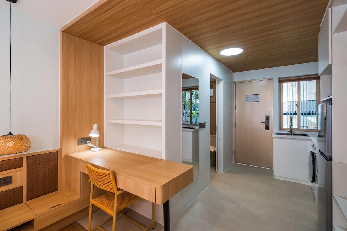 Una cocina moderna con encimera de madera, un lavamanos integrado y un refrigerador.