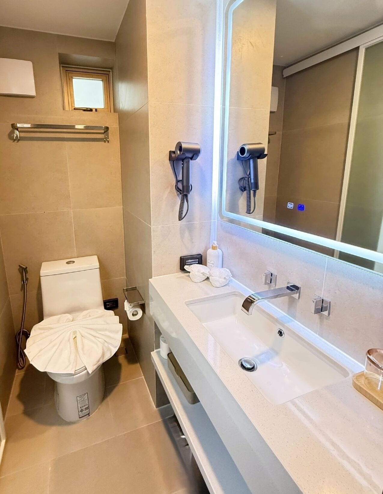 A bathroom with a toilet, bidet, and a large mirror.