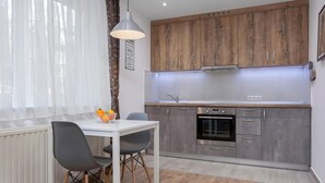 Eine moderne Küche mit Holzausstattung, integriertem Backofen und Essbereich mit Tisch und Stühlen.