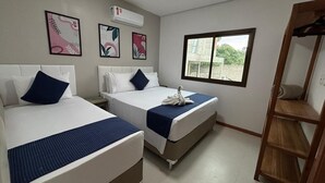 A hotel room with two beds, a window, and artwork on the walls. - Yellow House - Pitinga Beach - Arraial d'Ajuda (Arraial d'Ajuda)