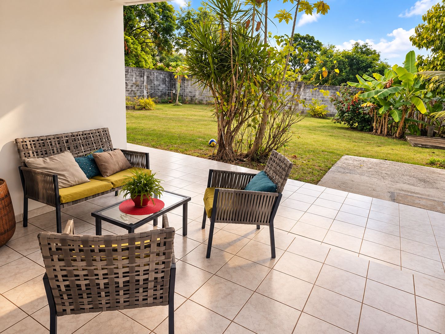 Eine Terrasse im Freien mit einer Couch, Stühlen und einem Tisch.