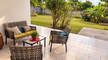 Eine Terrasse im Freien mit einer Couch, Stühlen und einem Tisch.