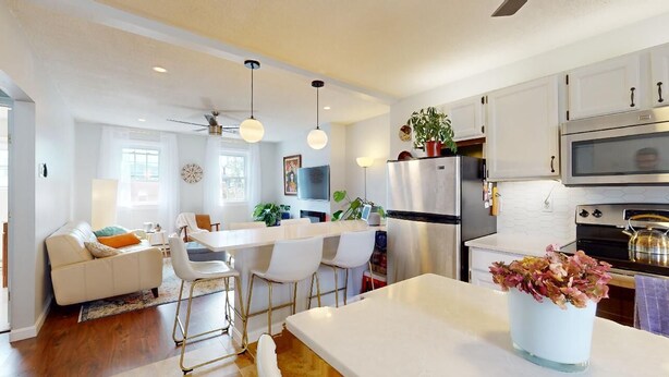 A modern kitchen with white cabinets, stainless steel appliances, and a central island. - Stylish East Boston Gem, Near Downtown, T and Airport (Boston)