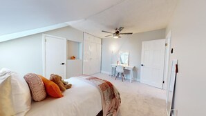 A bedroom with a bed, a desk, a mirror, and a ceiling fan. - Stylish East Boston Gem, Near Downtown, T and Airport (Boston)