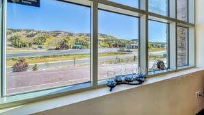 Una ventana con un cartel que dice 'Welcome home', vista de una carretera y tres vasos con piedras azules.