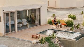 Ein Wüstenresort mit mehreren Zelten, einem Pool und Sitzgelegenheiten im Freien.
