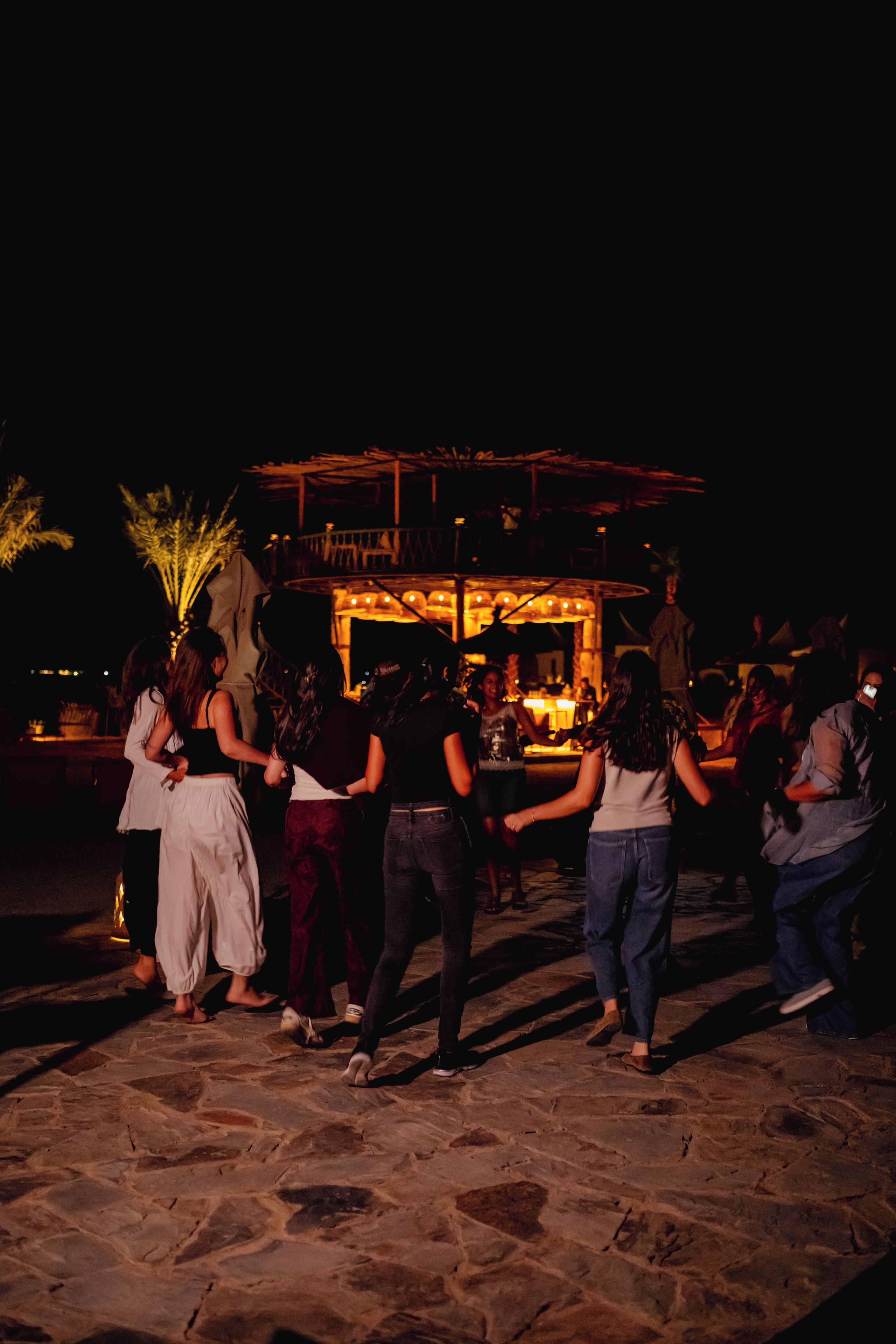 Un gruppo di persone balla su un patio in pietra di notte.