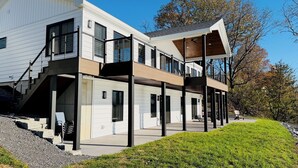 A modern two-story house with a covered porch and a garage. - A Luxury Lakeside Getaway (Aurora)
