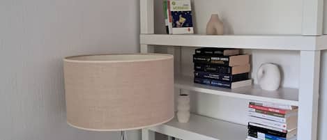 Une bibliothèque bien rangée, contenant divers livres et objets décoratifs.