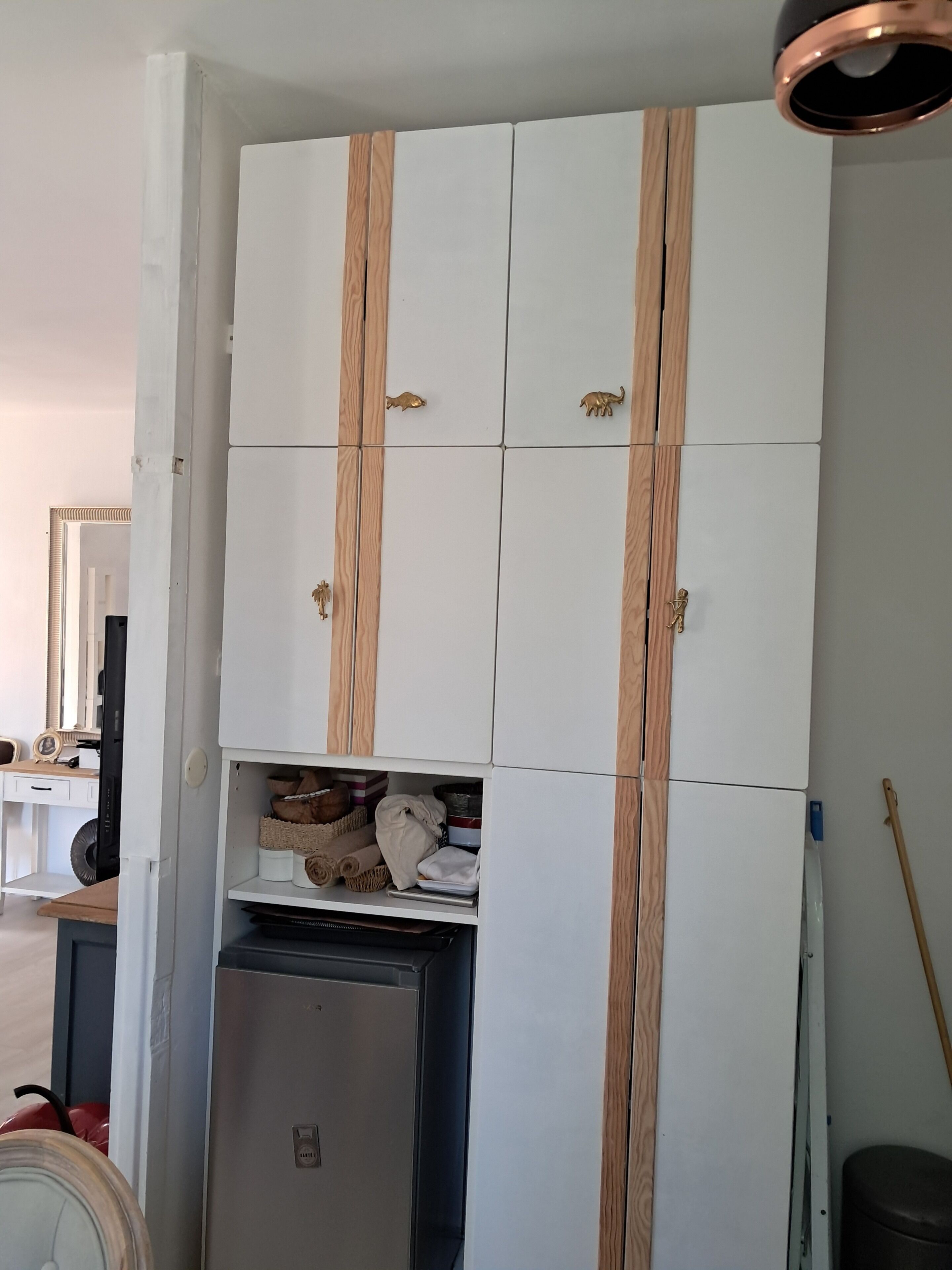 Una habitación con un armario blanco que presenta detalles de madera y una puerta de armario con espejo.