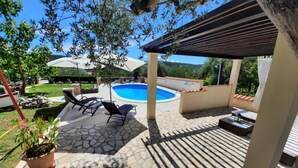 A covered outdoor area with a pool, lounge chairs, and a pergola. - Two Bedroom Apartment With Terrace (A3) (Kampor)