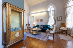 Ein Zimmer mit einem großen Holzkasten, einem blauen Sofa und einem Holzstuhl.