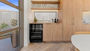 Una cocina moderna con armarios de madera, horno empotrado y ventana con vistas a un balcón.