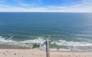 A beach with a pier extending into the ocean, sandy beach, and clear blue sky. - Spacious Beach House with Wraparound Porches in OCEAN GROVE (Ocean Grove)
