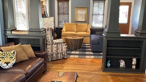 A living room with a brown leather sofa, a wooden coffee table, a patterned rug, and a fireplace.