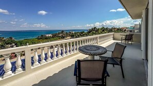 Un balcone con vista sull'oceano, un tavolo rotondo e due sedie.