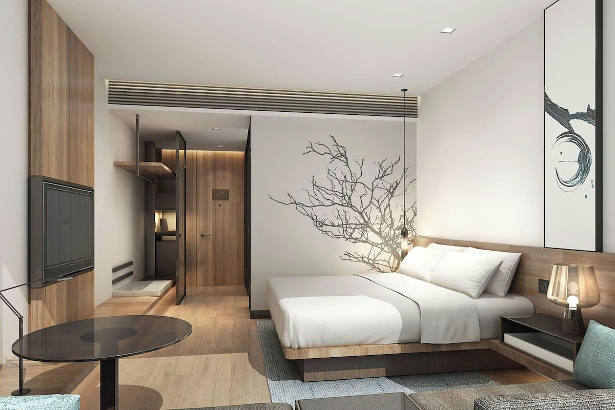 Une chambre d’hôtel moderne équipée d’un lit, d’une table de chevet et d’un téléviseur.